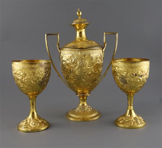A George III silver gilt two handled presentation pedestal cup and cover by Soloman Hougham and a pair of similar goblets, 47.5 oz